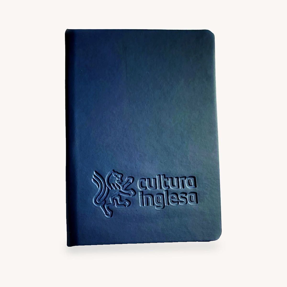 Caderno de couro azul-marinho com o leão e o nome Cultura Inglesa em baixo-relevo