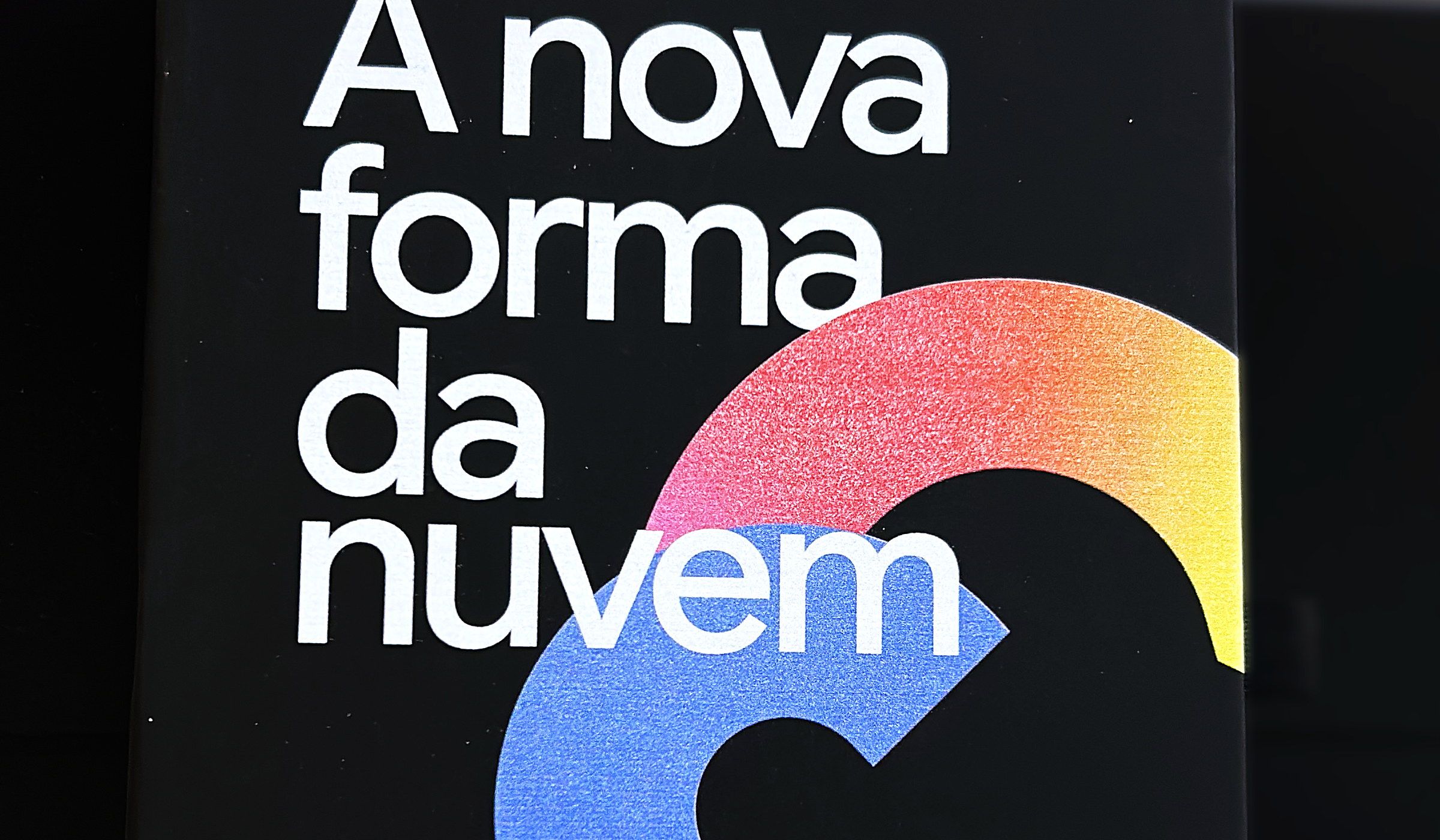 Caderno preto do Google Cloud com a frase A nova forma da nuvem e o símbolo em degradê impressos em Digital UV